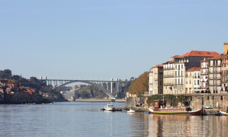 vista rio, com uma ponte ao fundo e um céu azul